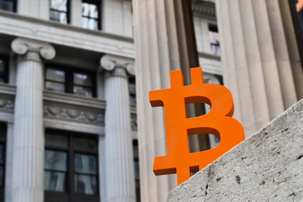 Bitcoin symbol against traditional bank building