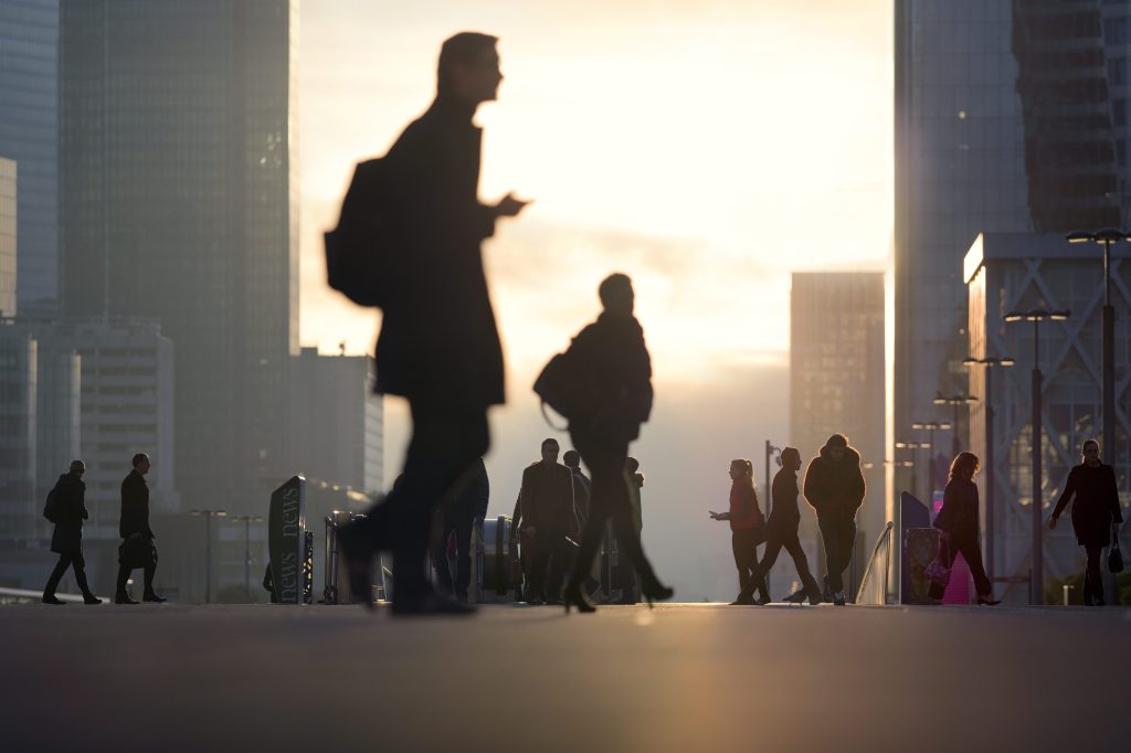 People silhouetted against buildings