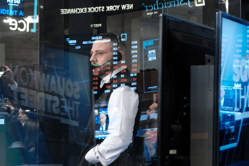 A trader looks worried, looking at the numbers on a screen.