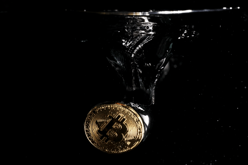 A bitcoin is falling down in water