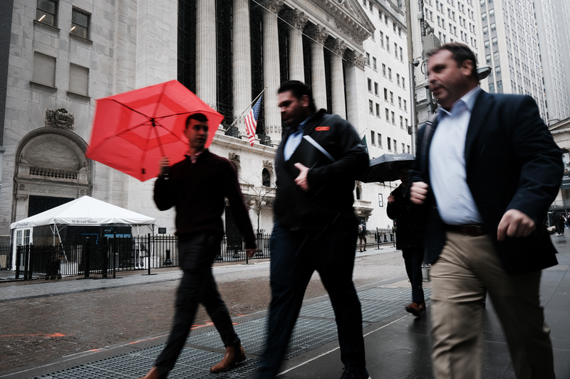 People walk through lower Manhattan by the New York Stock Exchange.