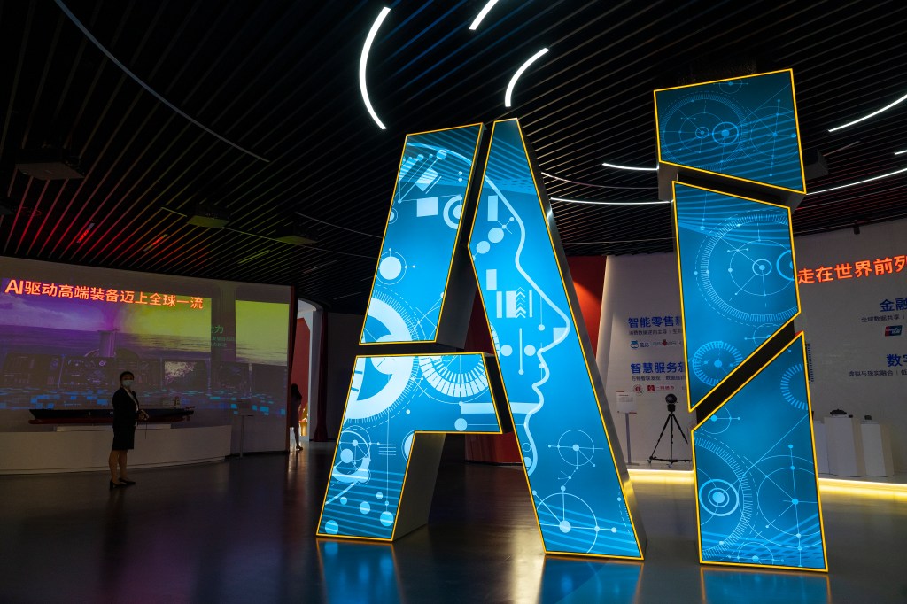 Picture of the letters in blue lighting saying "AI" on a stage