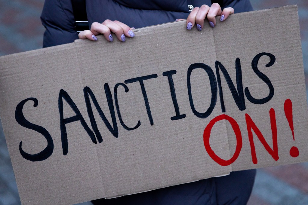 Cardboard sign saying "Sanctions On!"