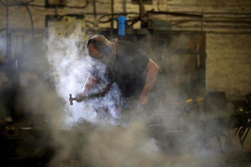 Foundry labourer breaks up steaming moulds