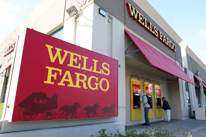Customers use ATMs at a Wells Fargo Bank.