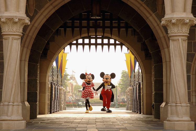 Mickey and Minnie Mouse are walking through Sleeping Beauty Castle at Disneyland Park .