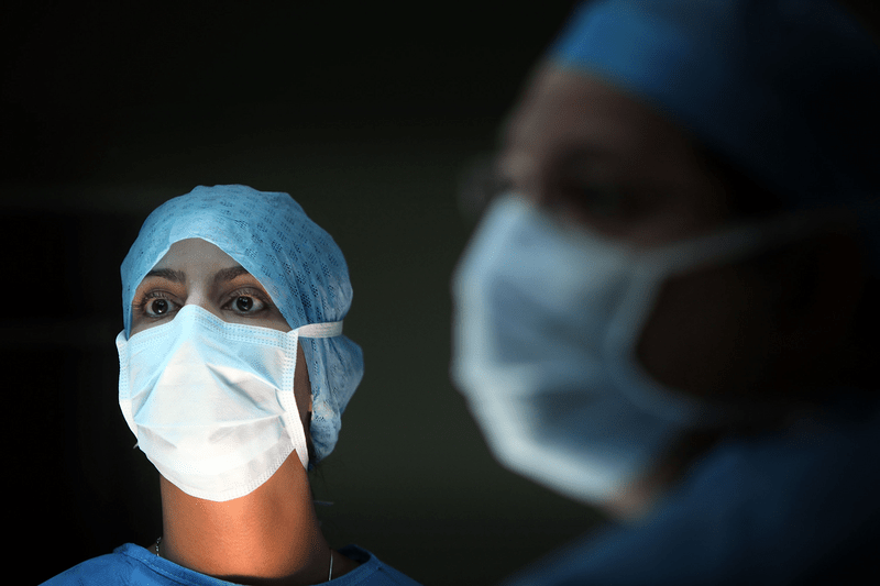 A surgeon and his theatre team are performing a surgery.