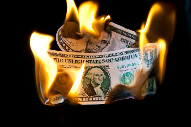 US five and one dollar bills are burning.