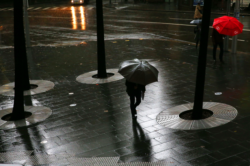 People are walking with umbrellas in wet weather.