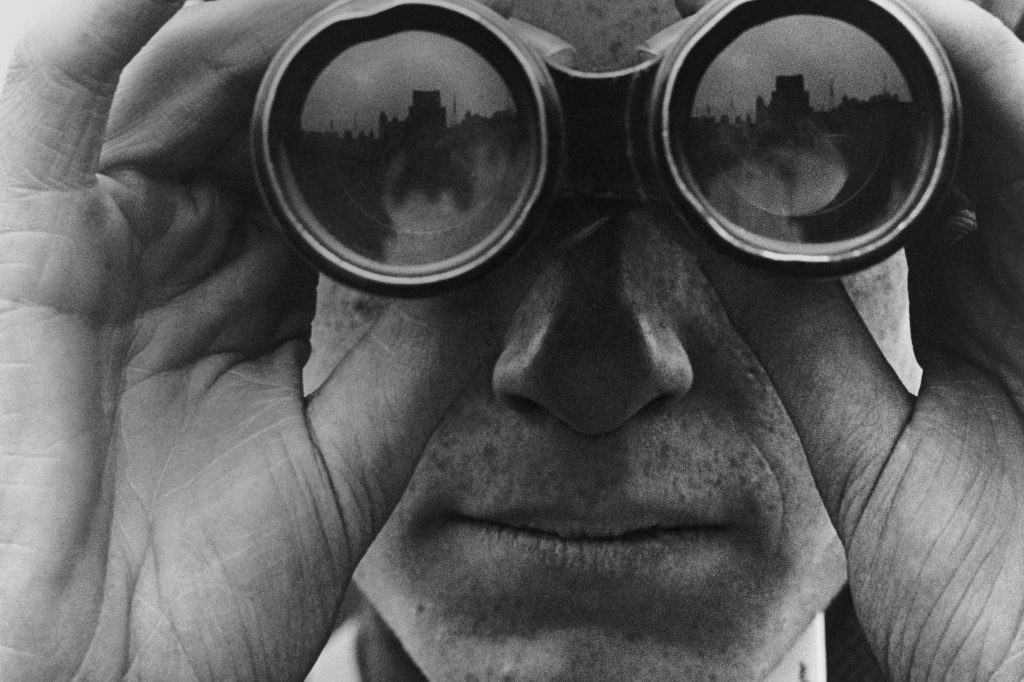 Image of a man looking through binoculars.