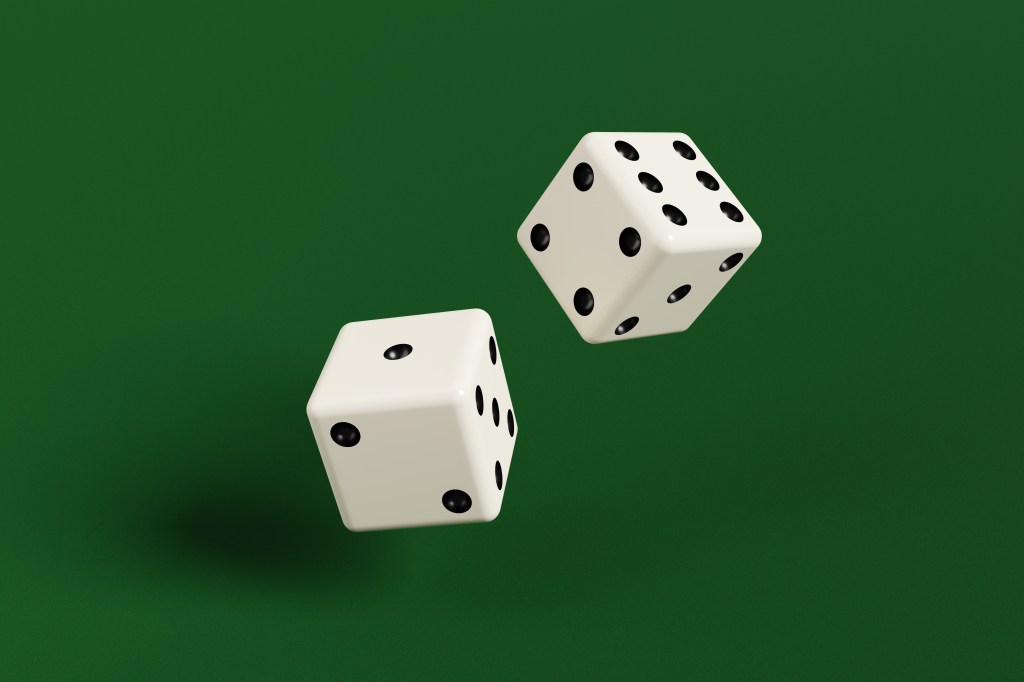 Two dice being thrown on green table