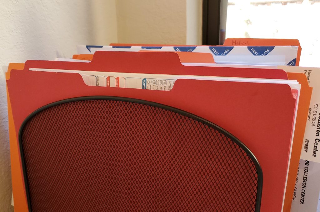 Image of a metal organizer holding vertical folders of papers.