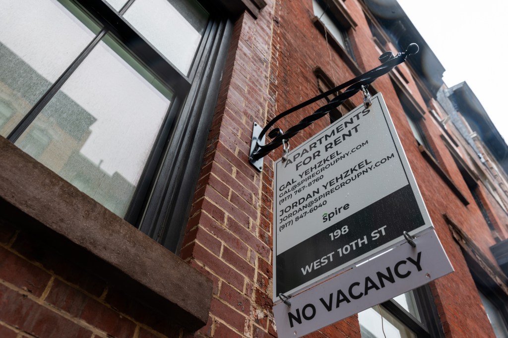 Image of a sign advertising units for rent outside of an apartment building in NYC.