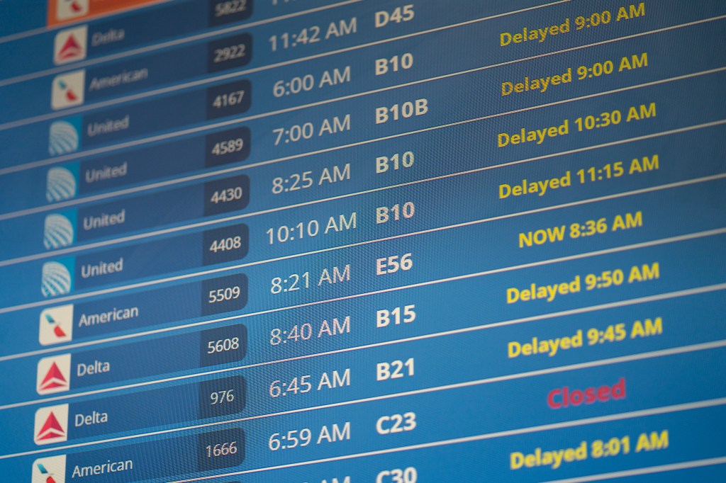 Image of a flight board at an airport showing Delta flights delayed.