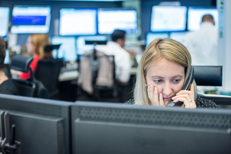 Woman looks at screens.