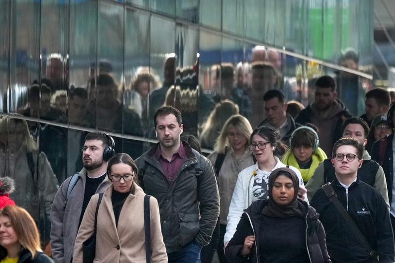 Commuters make their way to work in Manchester City centre on March 26, 2024 in Manchster, United Kingdom.