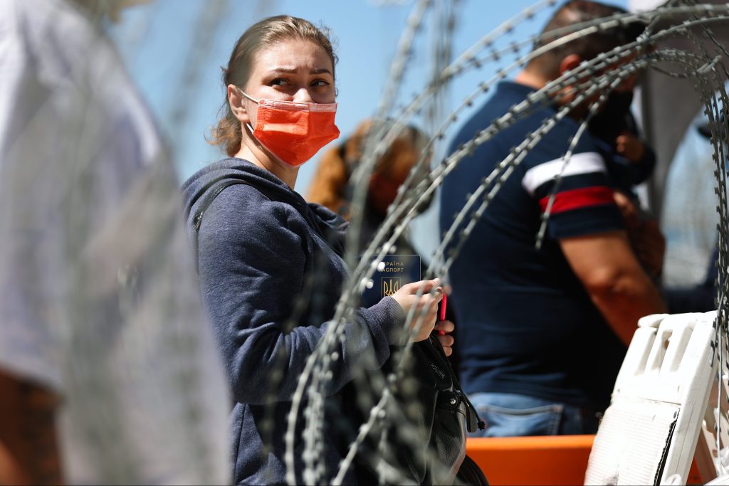 Migrant at barbed wire border barrier