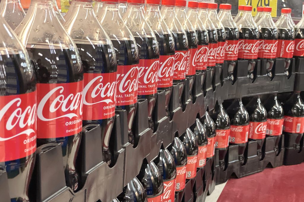 Image of an array of Coca Cola plastic, single-use bottles.