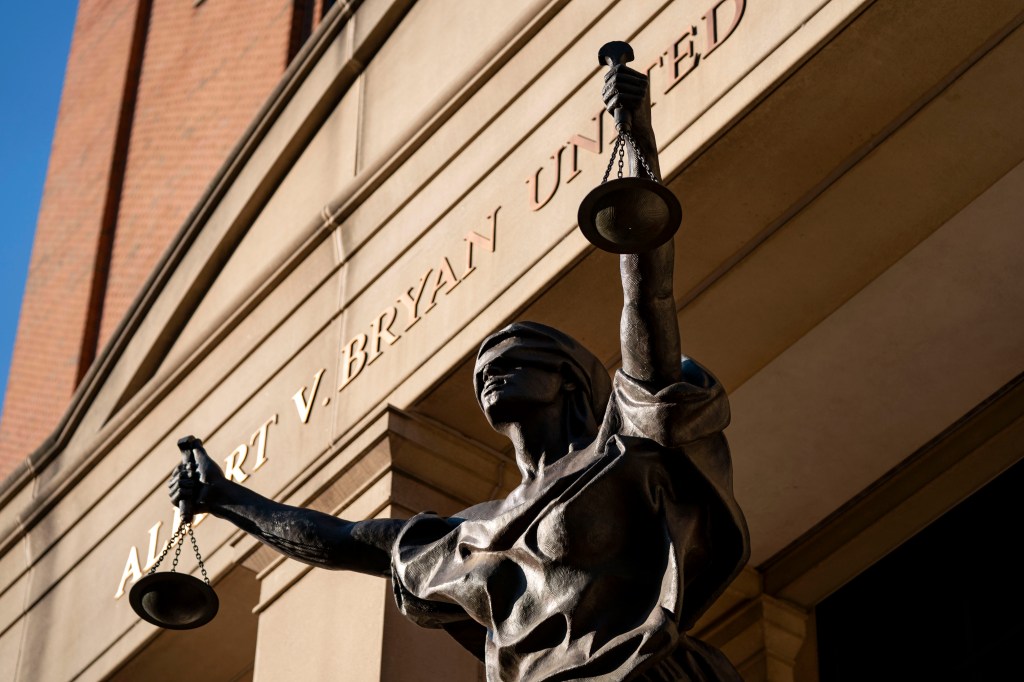 Image of a courthouse with a sculpture of Lady Justice in front of it.