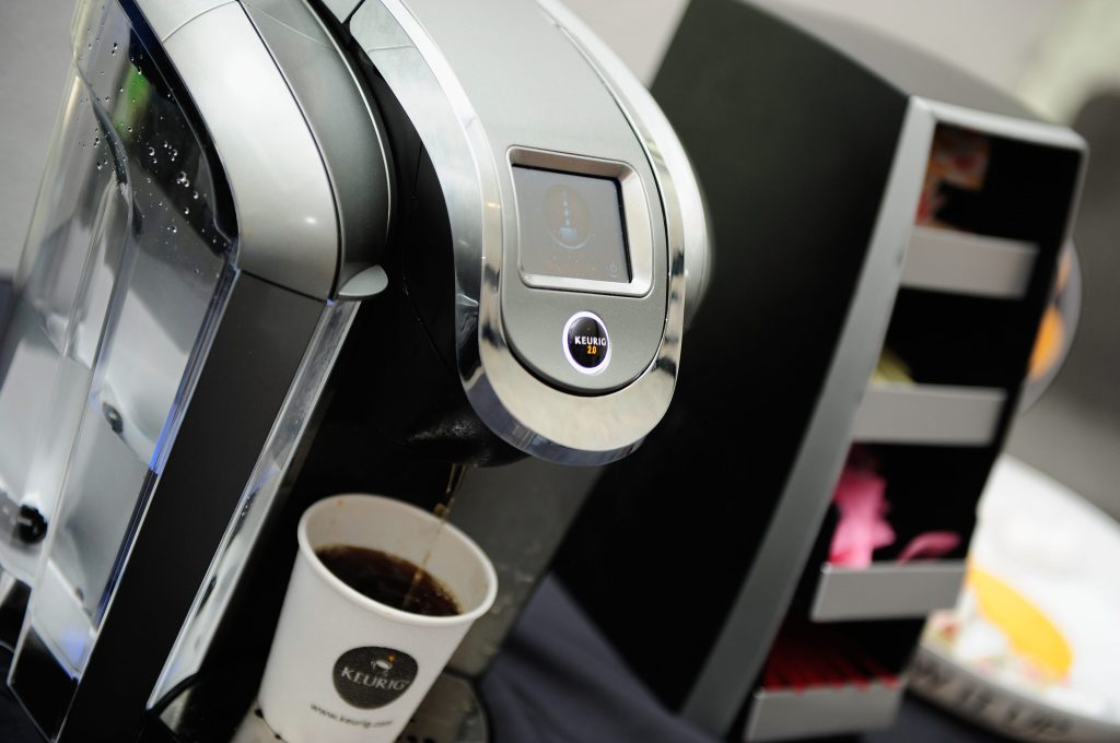 Image of a Keurig machine and cup of coffee inside it.