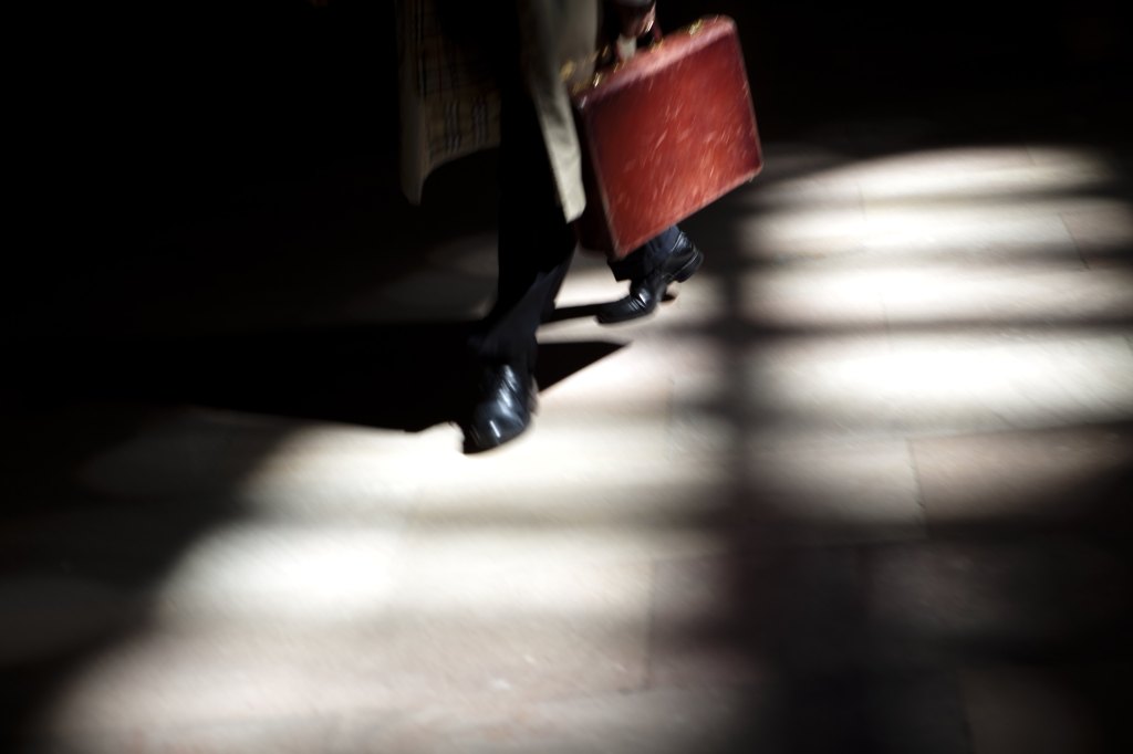 Man carrying briefcase in shadow