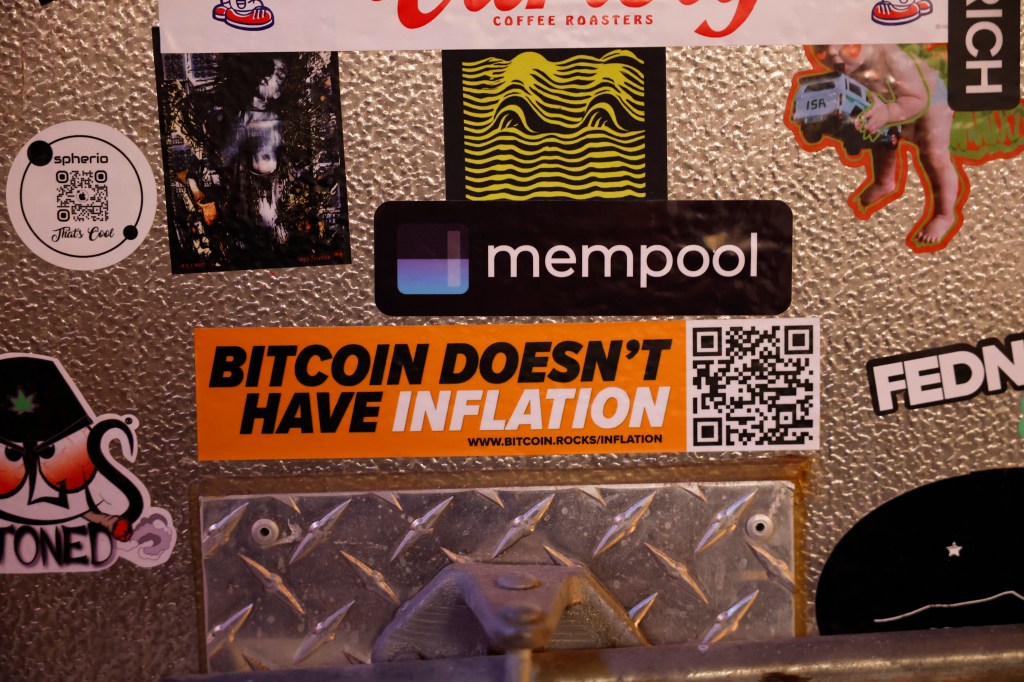 Image of several bumper stickers, once of which says "Bitcoin doesn't have inflation."