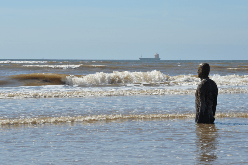 Another Place art installation on the beach at Crosby, Liverpool, England.