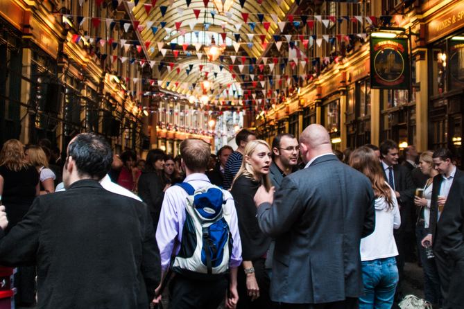 Crowds gather in Leadenhall Market socializing as they make their way through.