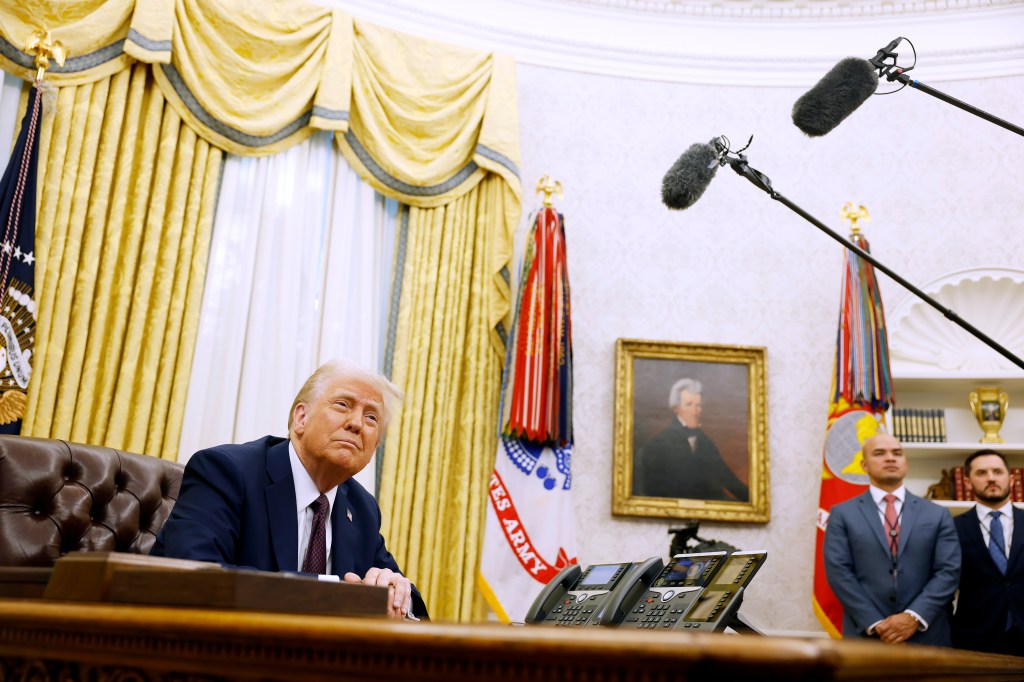 Image of President Trump in the Oval Office, signing executive orders.