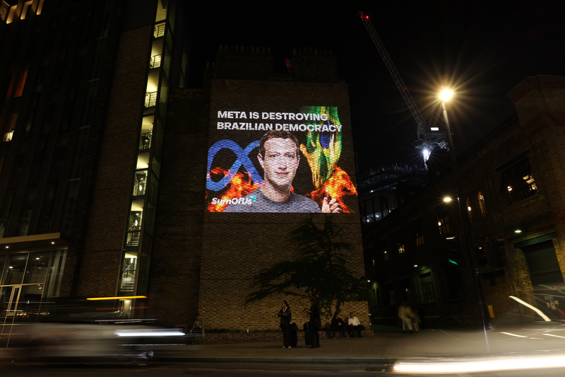 Activists project an image of Mark Zuckerberg onto a wall outside Kings Cross St. Pancras on October 29, 2022 in London, England. The projection's organiser, SumOfUs, accused the social media company and its founder Mark Zuckerberg of "destroying Brazilian democracy" by letting disinformation propagate on its platforms. 