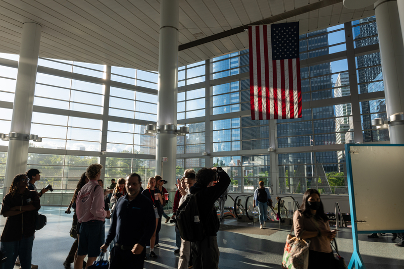 Commuters walk under an American flag at the Staten Island Ferry terminal in Manhattan.