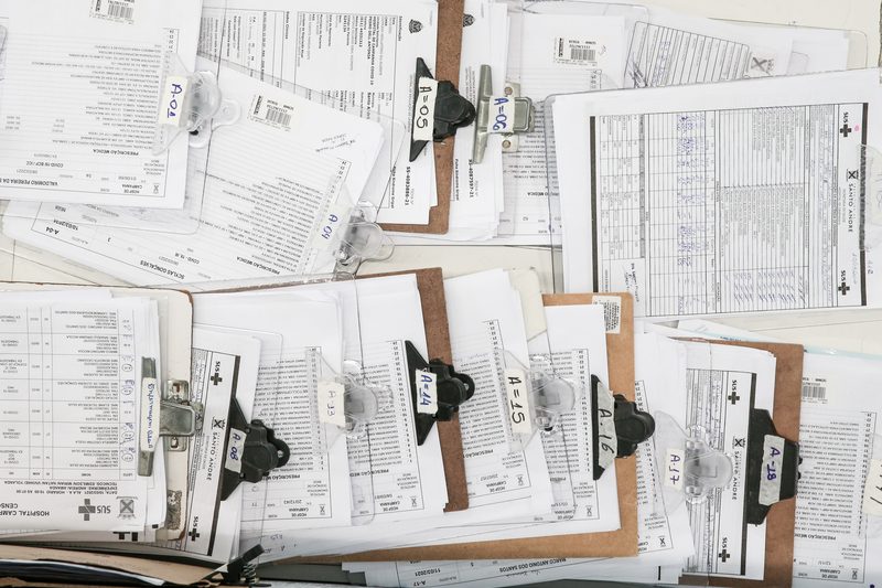 Lots of patient's files spread out on a table.